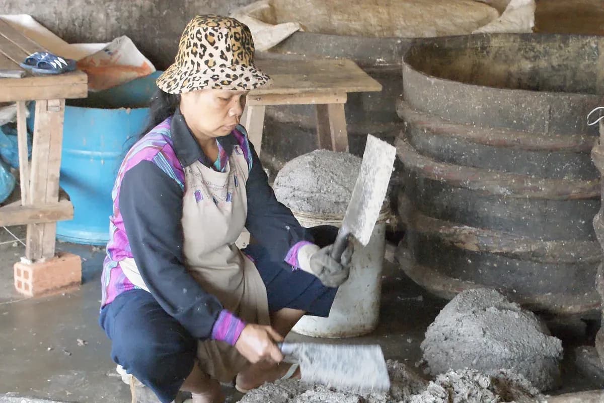 カンボジアで、女性が魚のペーストを作っている様子。